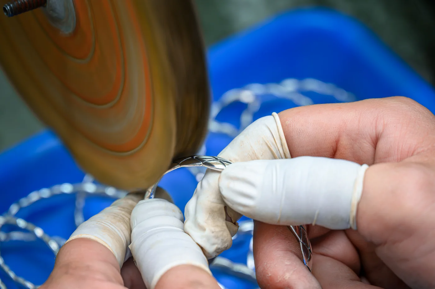 Close-up of a jewelry piece being polished by hand
